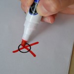 Hand mit Stift macht Kreuz