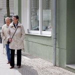 zwei alte Menschen vor Wohnhaus
