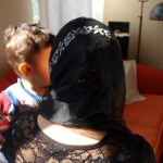 Frau mit Kopftuch hält Kind auf dem Arm