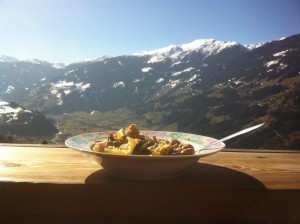 Teller mit Speise vor Alpenpanorama
