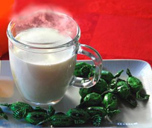 Erkältungszeit, Glas mit heißer Milch und Hustenbonbons