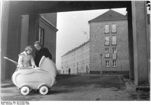 Zwei Mädchen hinter einem Babywagen der 50ger Jahre