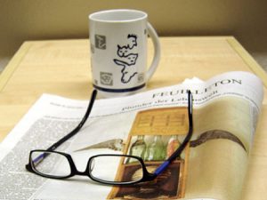 Zeitung mit Brille und Kaffeetasse