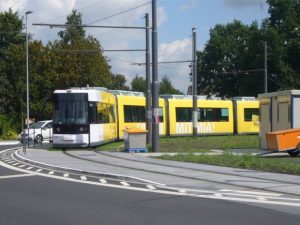Eine gelbe Straßenbahn in der Kurve