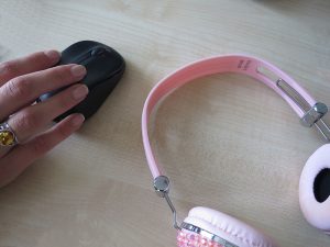 Bluetooth, Hand mit Funkmouse und rosa Köpfhöhrern