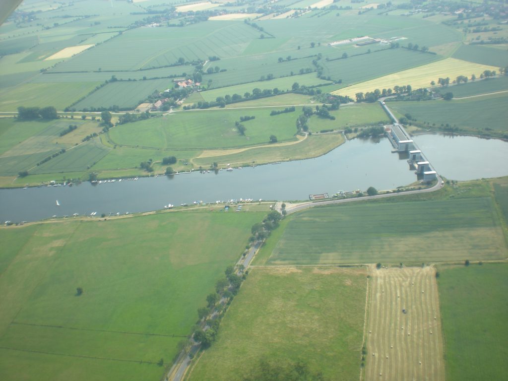 Luftaufnahme der Weser mit Wehr und Feldern