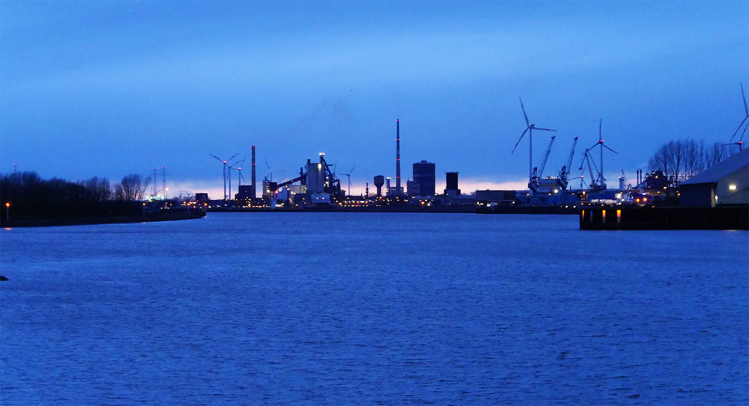 Blick auf Hafenanlagen im blauen Abendlicht