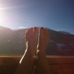 Hochgelegte Füße vor Sonnenaufgang in den Bergen