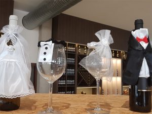 Weinflaschen und Weingläser mit Hochzeitsschmuck